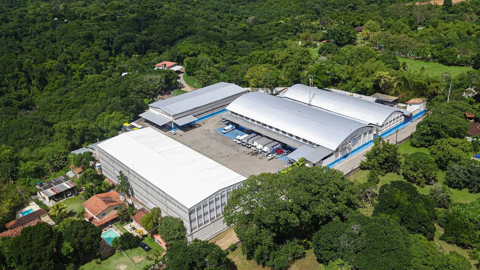 Vista aérea da estrutura da Ultramega: galpões de cobertura branca em meio à vegetação